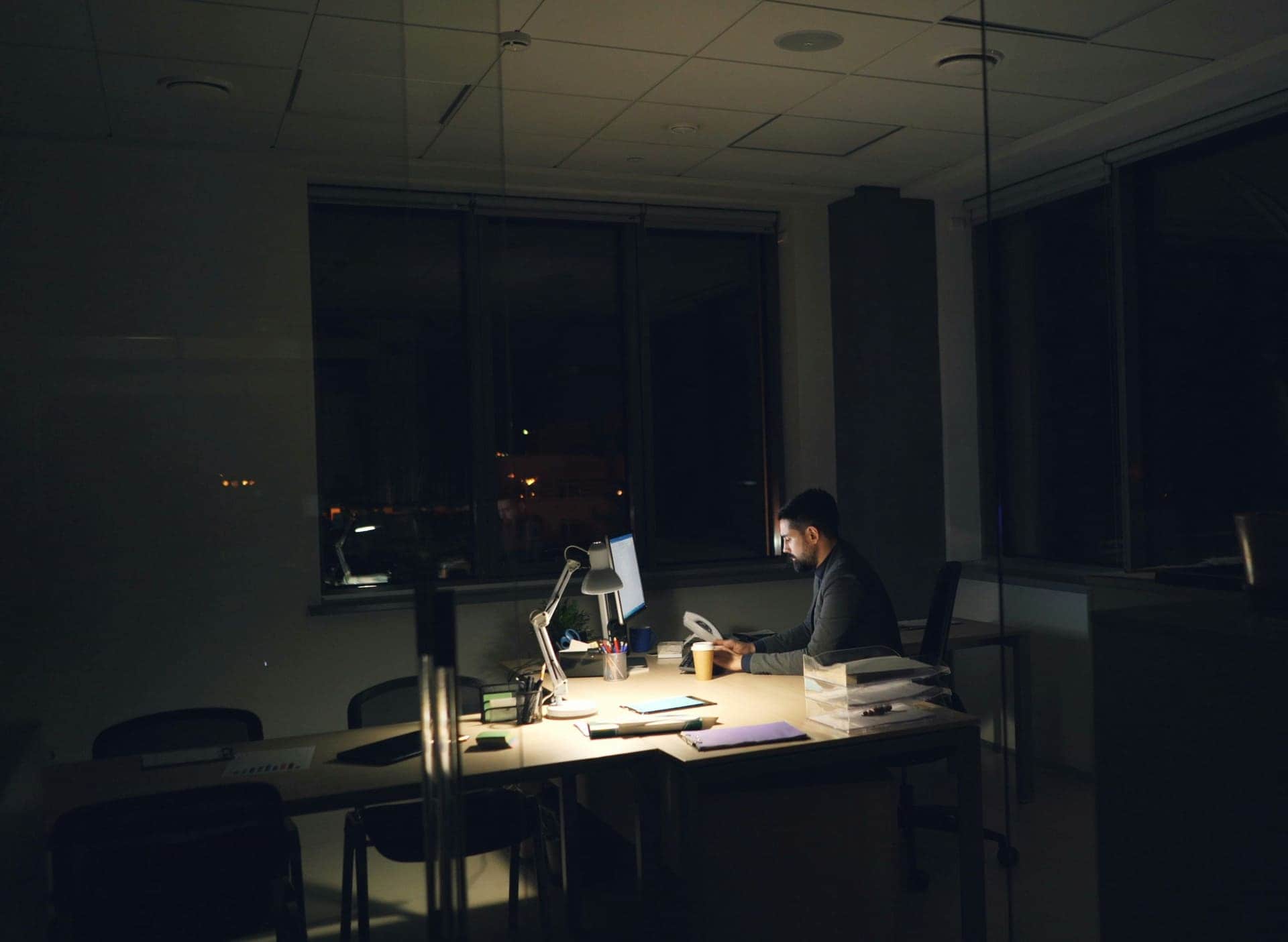 Oficina de noche con una persona trabajando en su escritorio